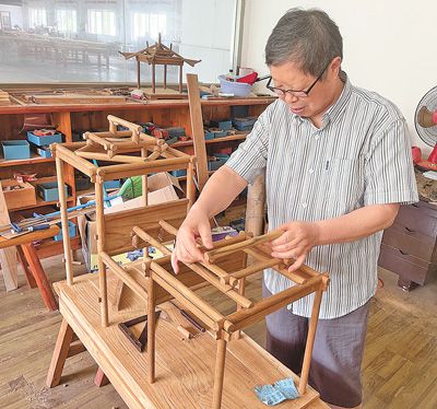 陸耀祖在搭建建筑模型。