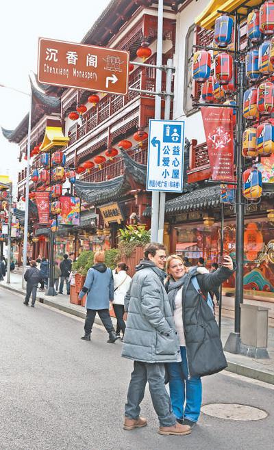 外國游客在上海街頭打卡留念。本報記者 崔 寅攝
