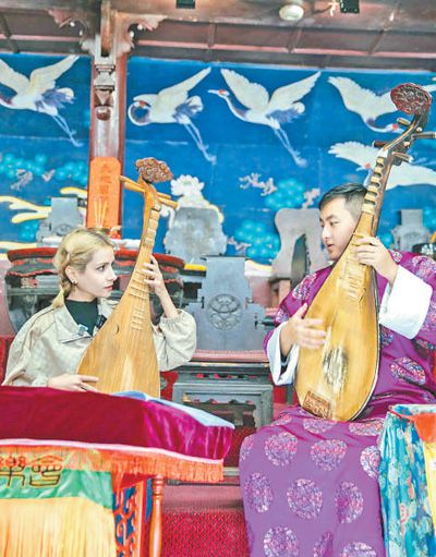 來自伊朗的游客在云南麗江大研納西古樂會學習古樂演奏。和雪婷攝