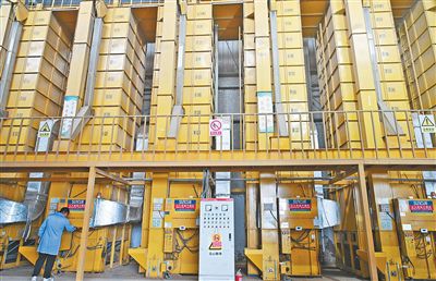 太倉一處烘干中心的工作人員正在調(diào)整烘干機水分設置。